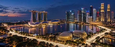 Destination artwork of Singapore: Marina Bay at night, illuminated waterfront skyline and glowing street circuit, humid blue-hour atmosphere.