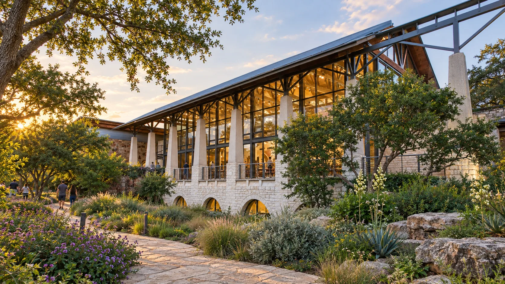 Glazed Great Hall above native gardens in warm evening light