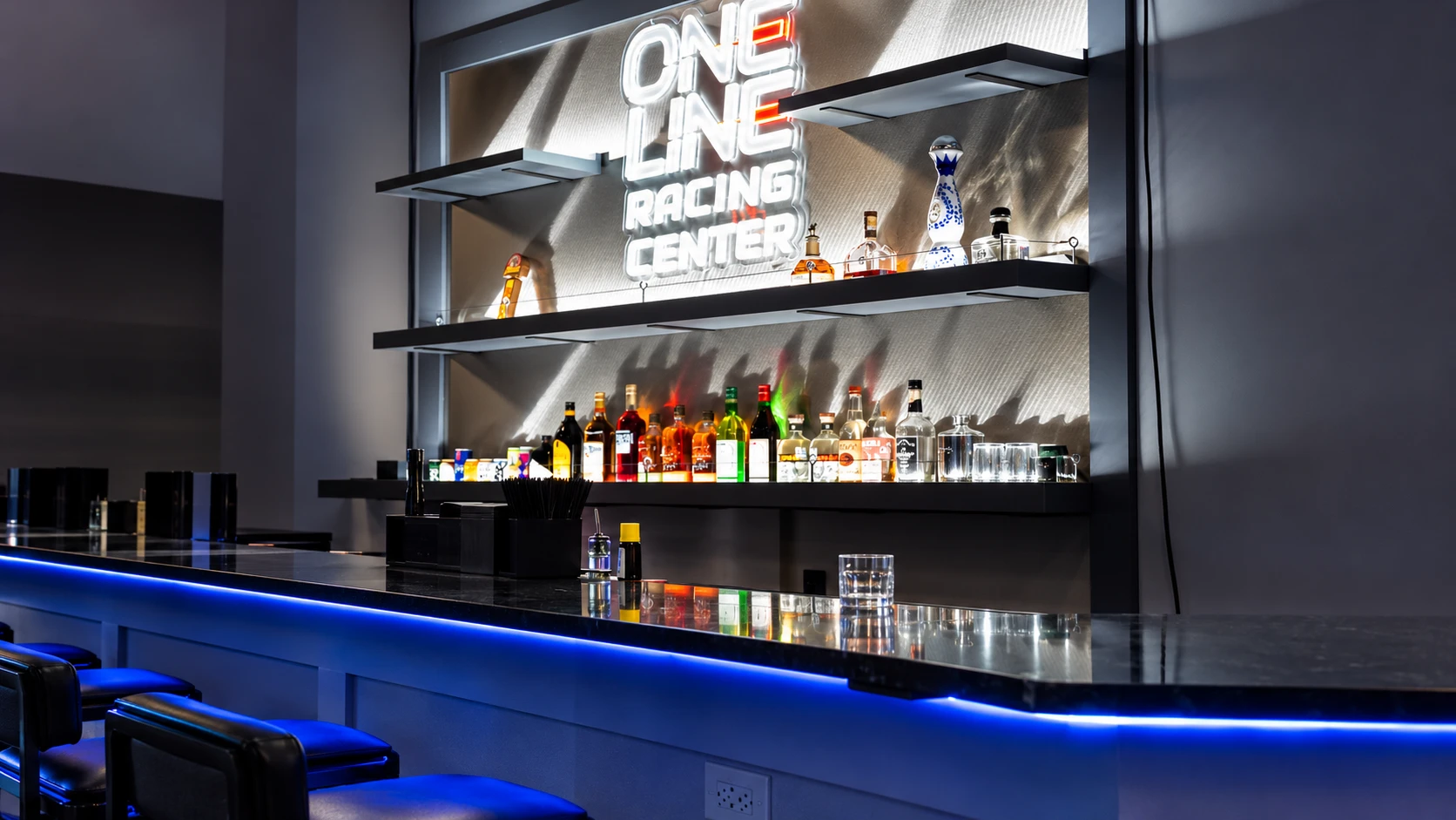 The bar counter and illuminated sign at One Line Racing Center