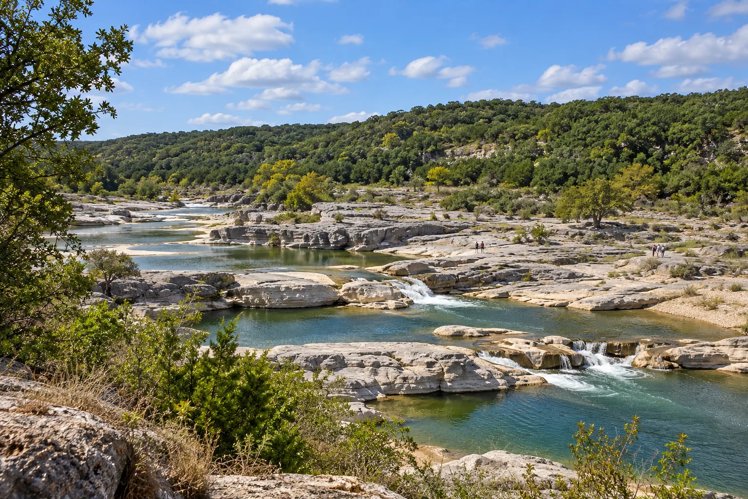 Layered limestone channels and green pools at the Pedernales Falls area