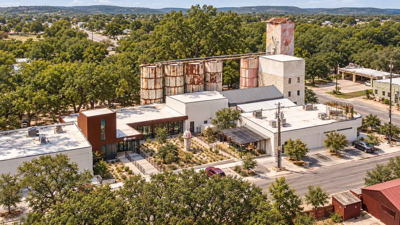 The Science Mill complex and historic silos among the trees of Johnson City