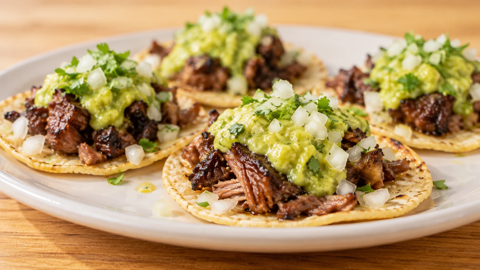 Tacos topped with meat, onion and green salsa at Suerte