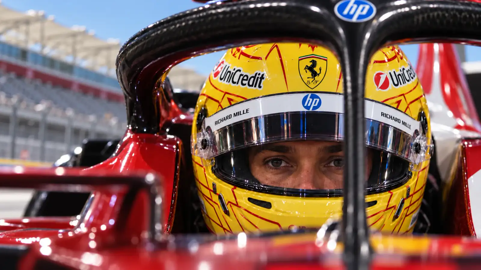 Lewis Hamilton behind the raised helmet visor in the COTA pit lane