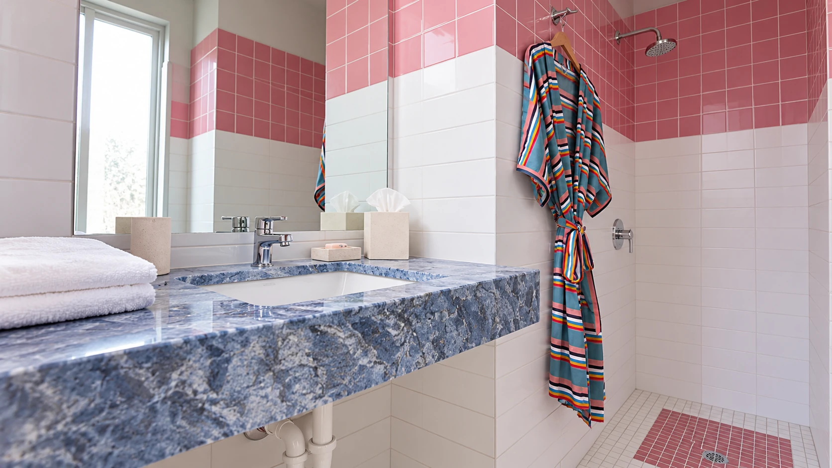 Pink tiles and a vanity in a shared private bathroom for The Cabins at East Austin Hotel