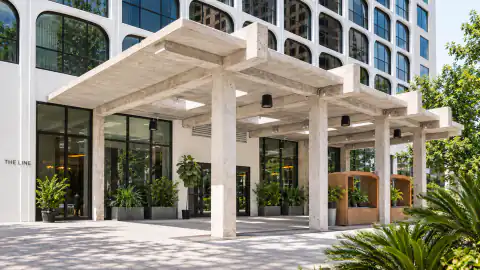 Concrete entrance canopy and rounded window grid at The LINE Austin