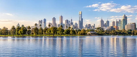 Destination artwork of Melbourne: Albert Park lake, green parkland and the Melbourne skyline in crisp bright southern summer light.