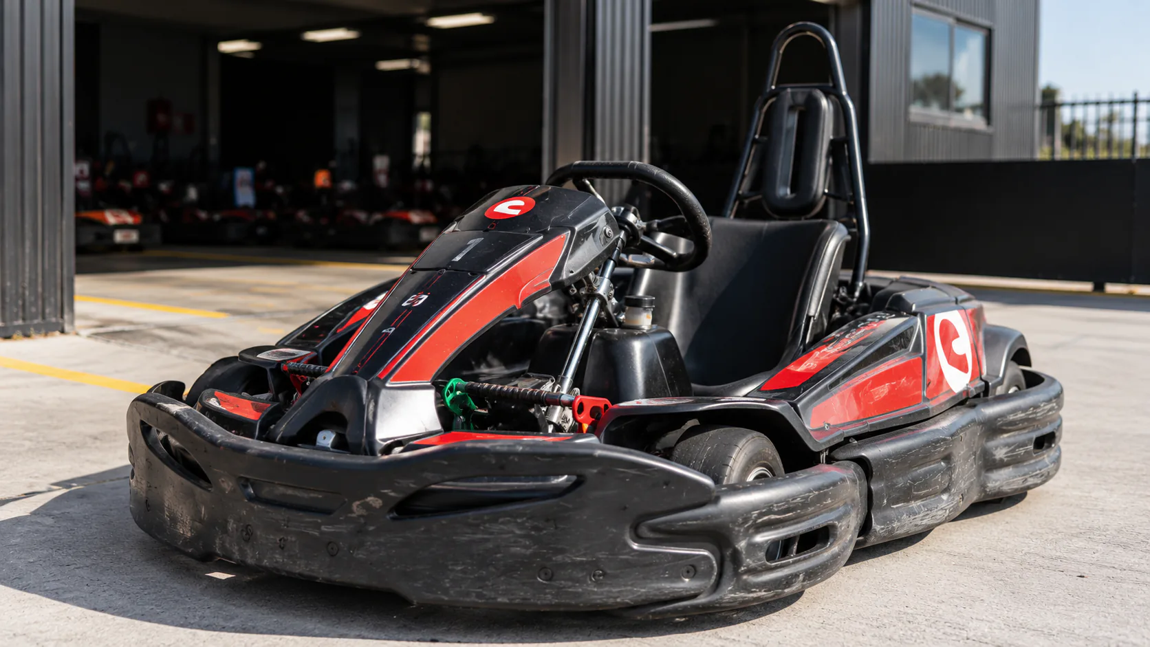 A red and black Sodi kart beside the pit garage at Ace Karts in Albion.