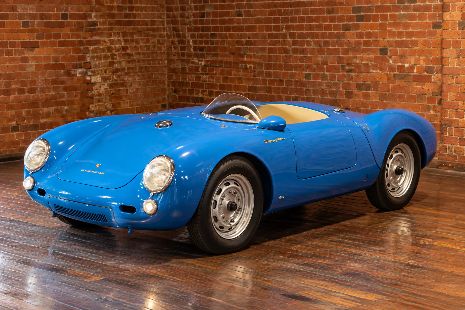 The blue Porsche 550 Spyder, from its rounded nose to its rear bodywork.