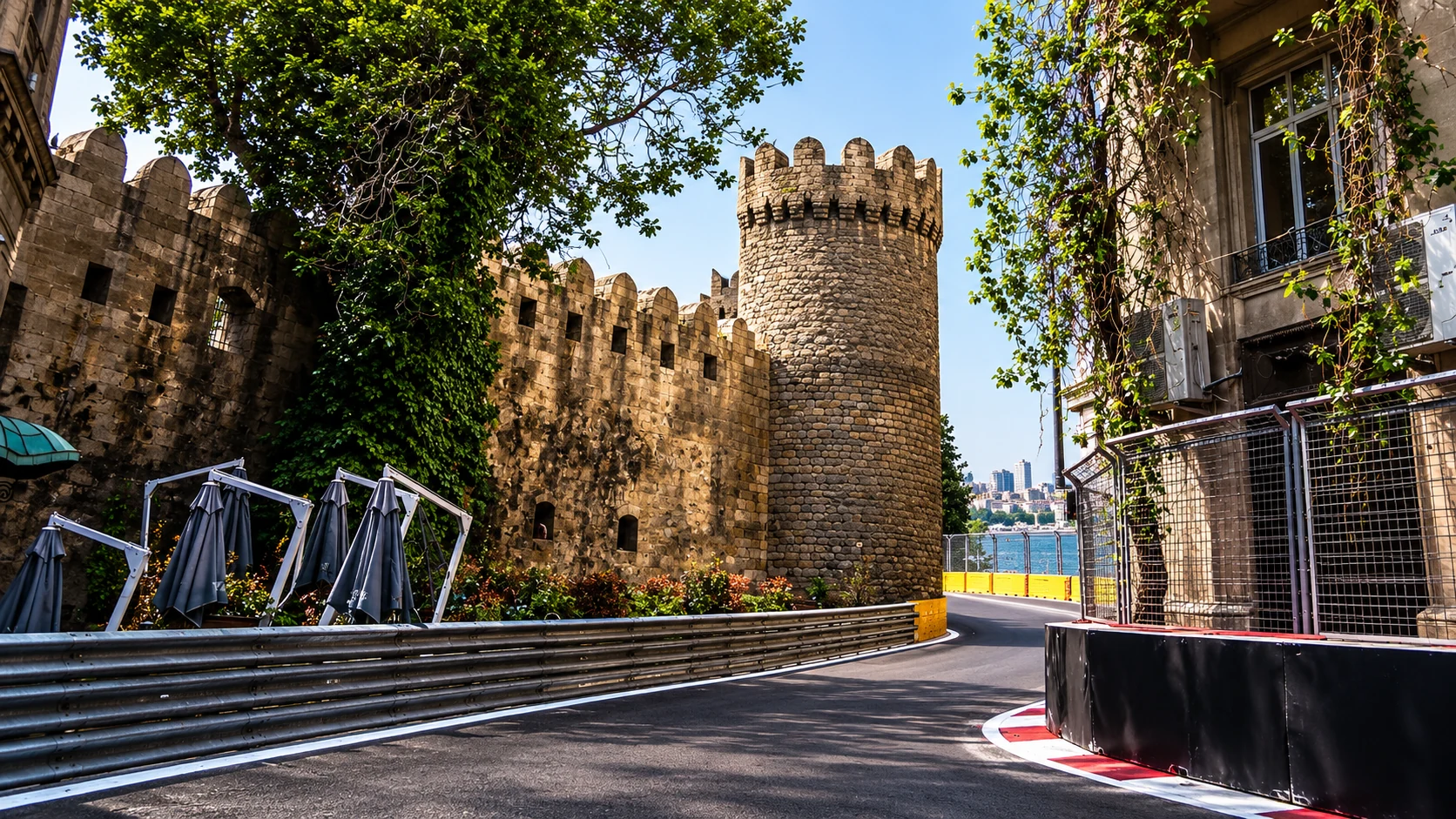 A round tower and stone ramparts rise beside Baku’s tree-lined circuit and trackside barriers.
