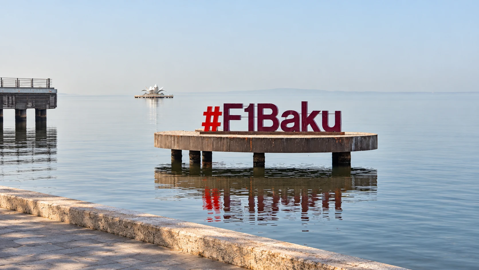 The F1 Baku sign stands over the Caspian Sea on a low waterfront platform.