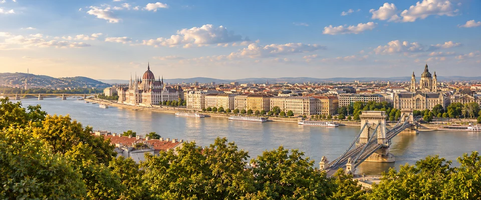Destination artwork of Budapest: Budapest panorama across the Danube, elegant riverside architecture, bridges and Buda hills in warm summer light.