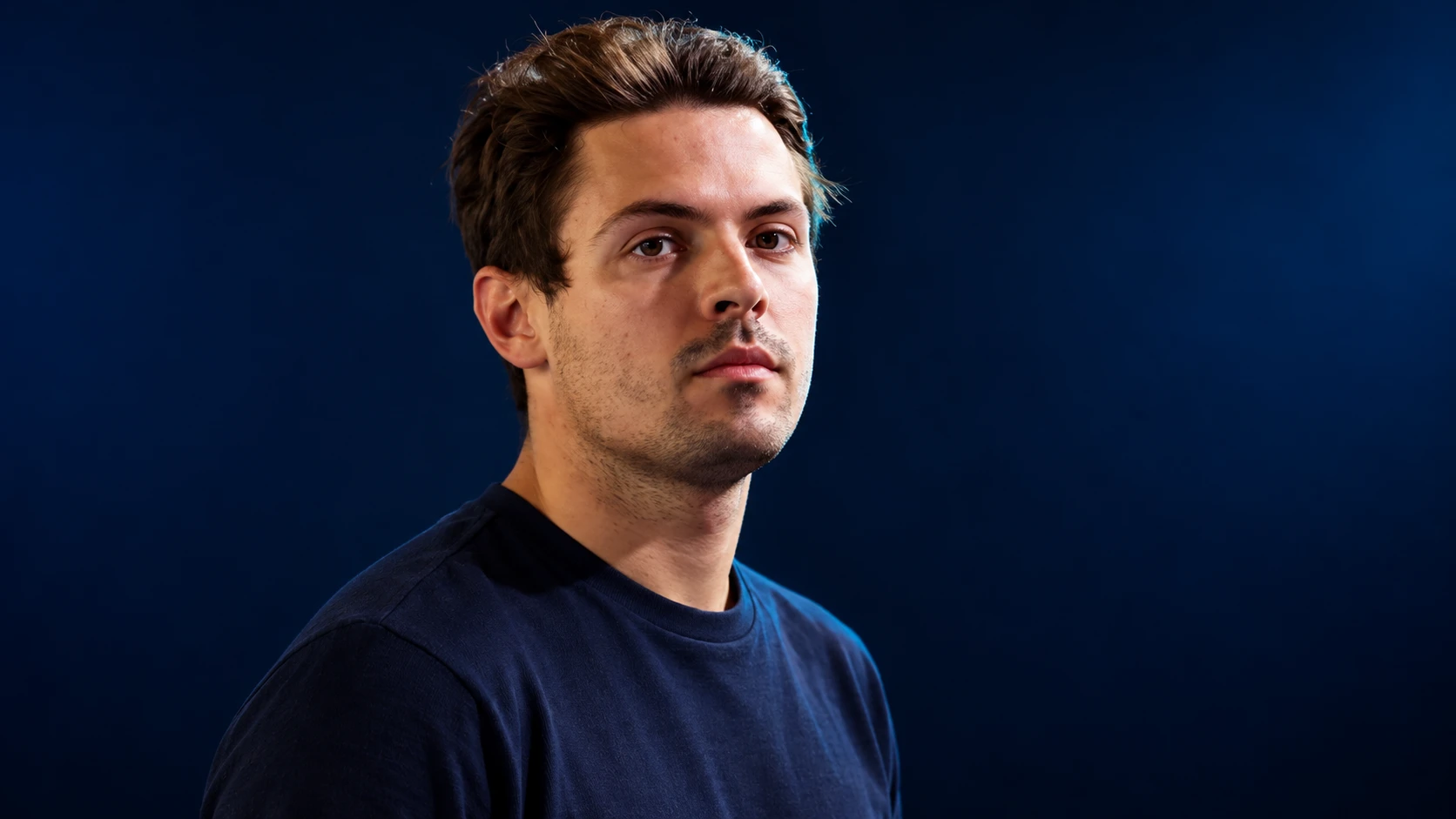 Felipe Drugovich in a navy shirt against a dark background.