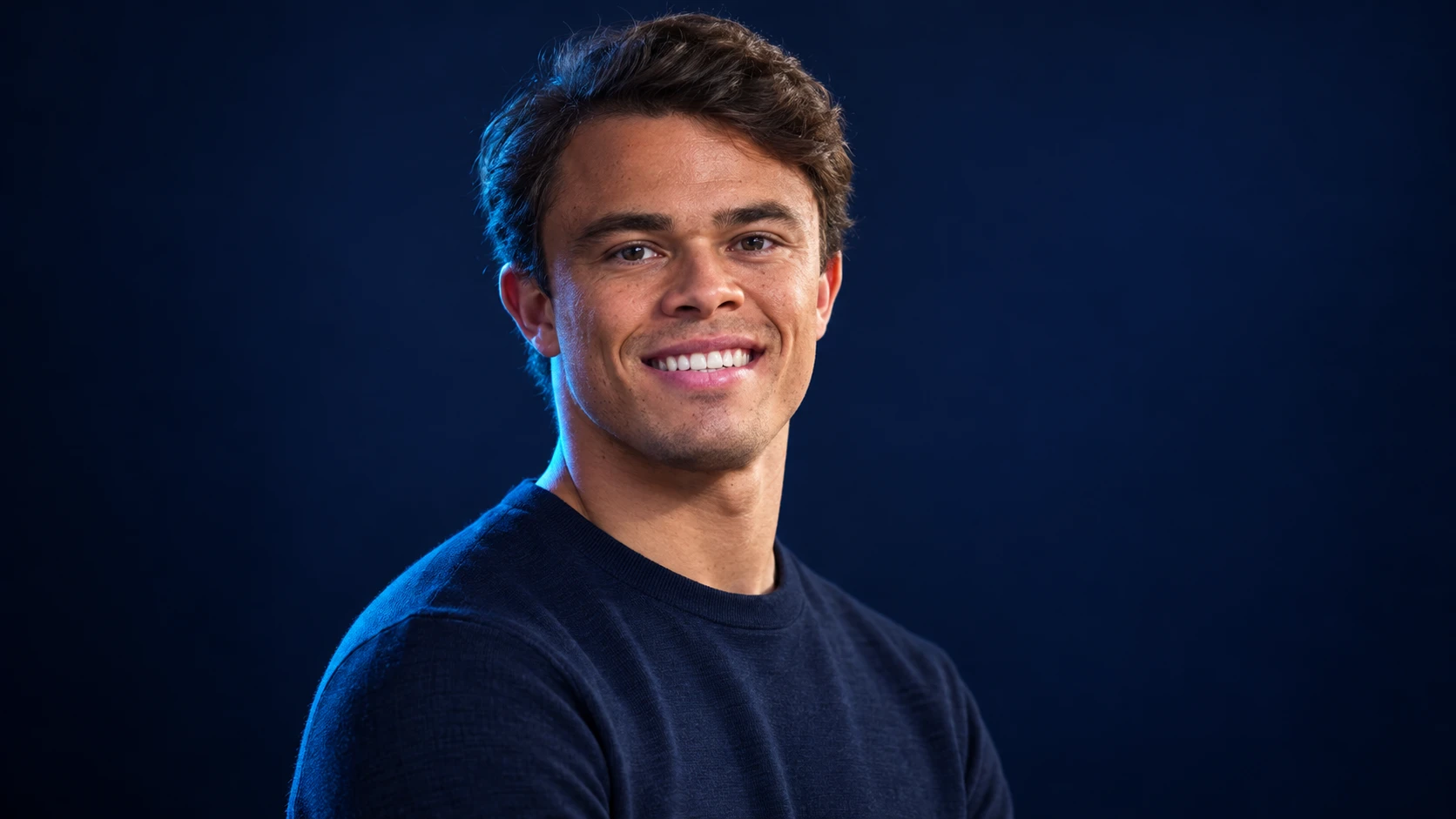 Nyck de Vries in a navy shirt against a dark background.