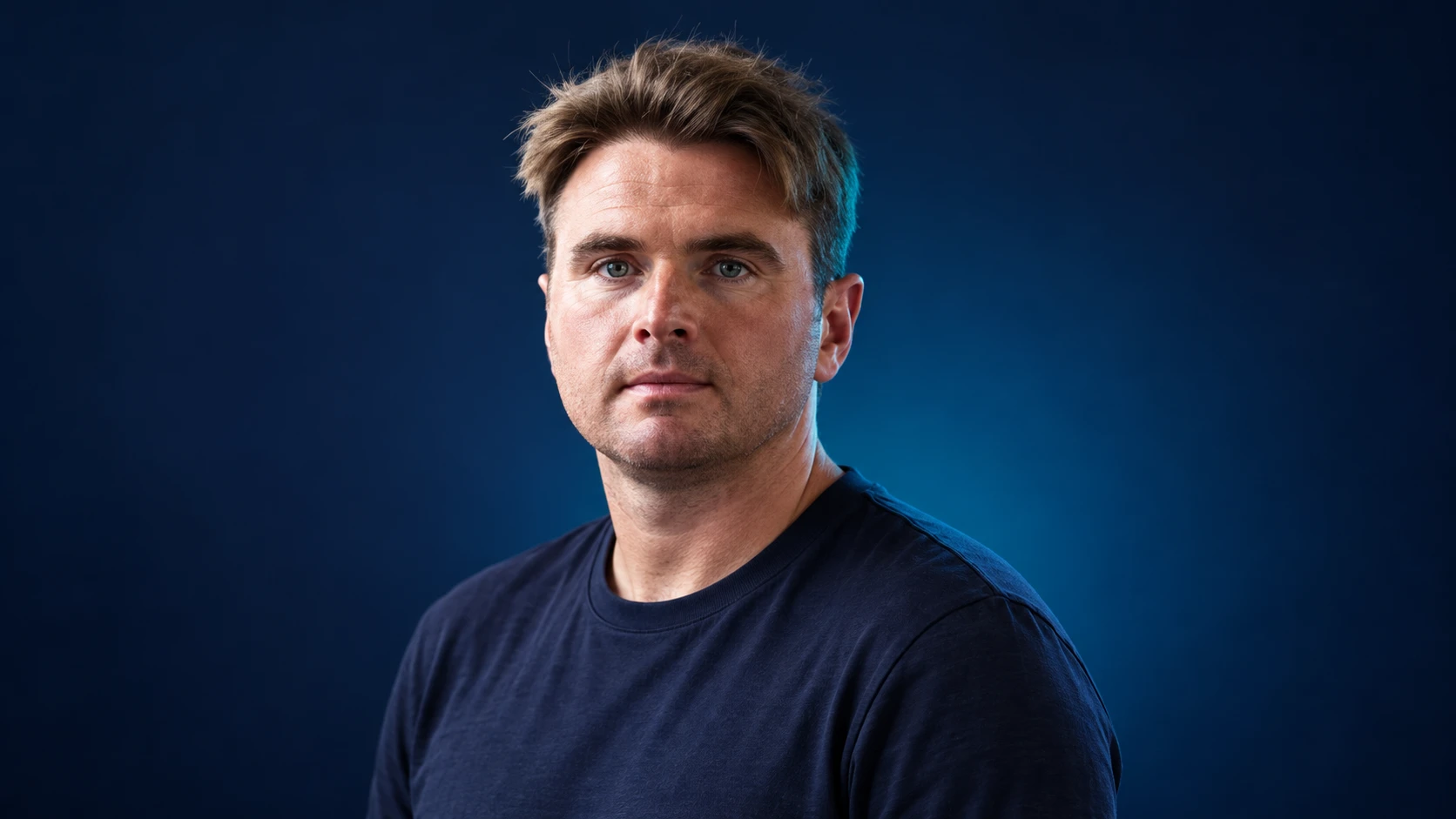 Oliver Rowland in a navy shirt against a dark background.