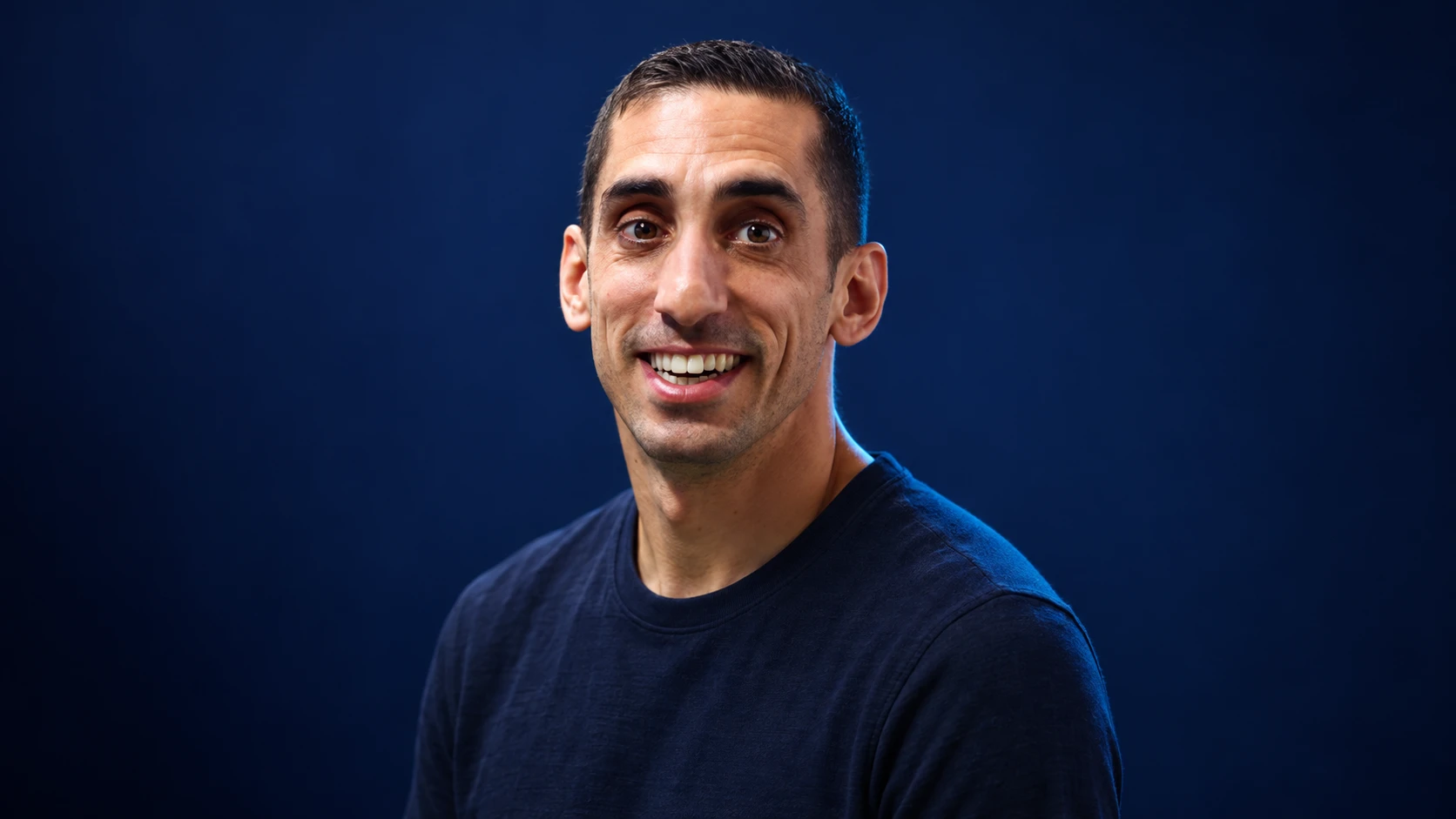 Sébastien Buemi in a navy shirt against a dark background.