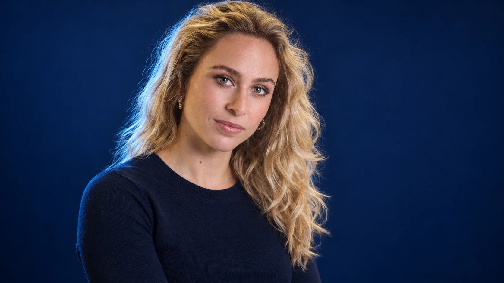 Sophia Flörsch in a navy shirt against a dark background.