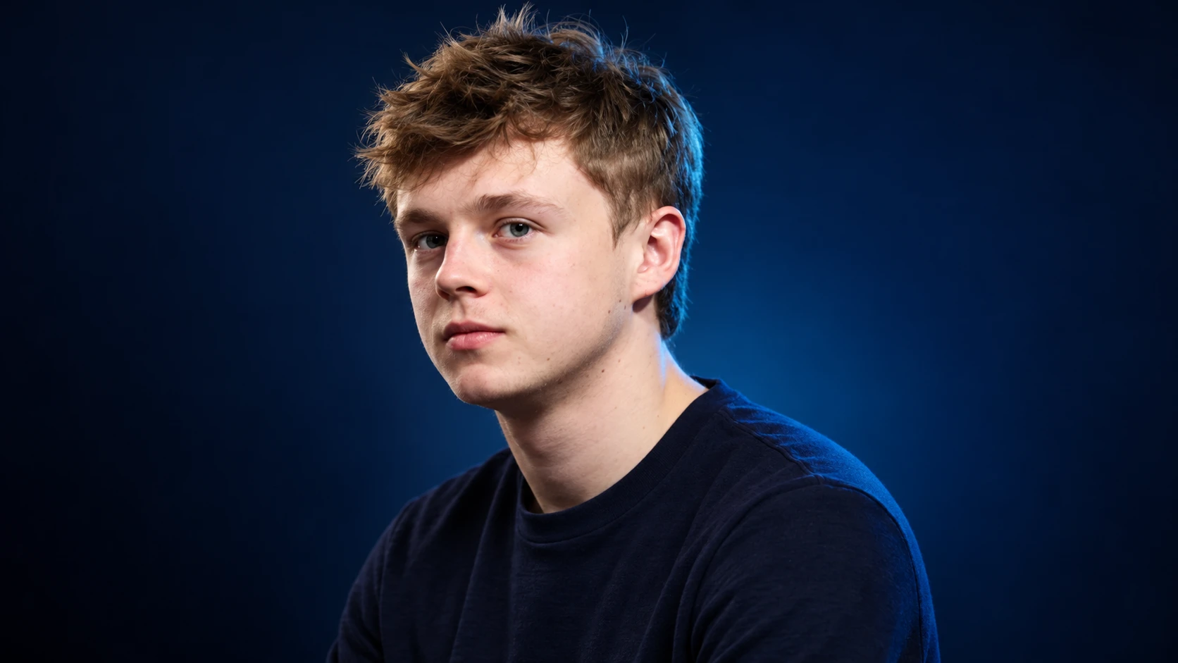 Taylor Barnard in a navy shirt against a dark background.