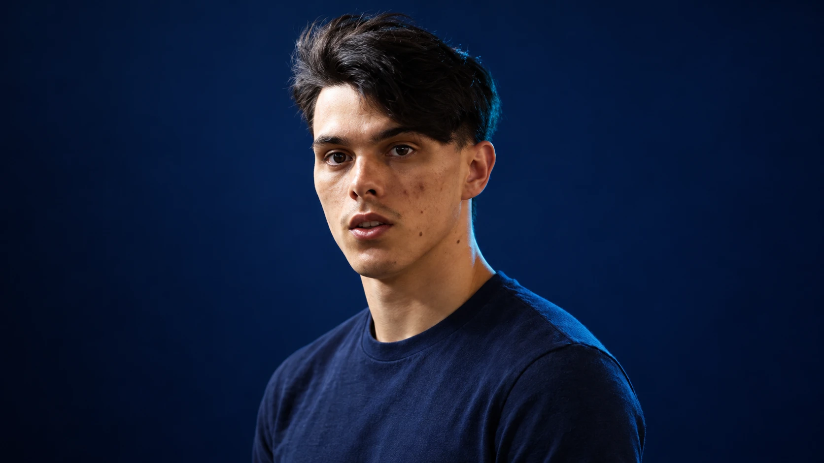 Zane Maloney in a navy shirt against a dark background.