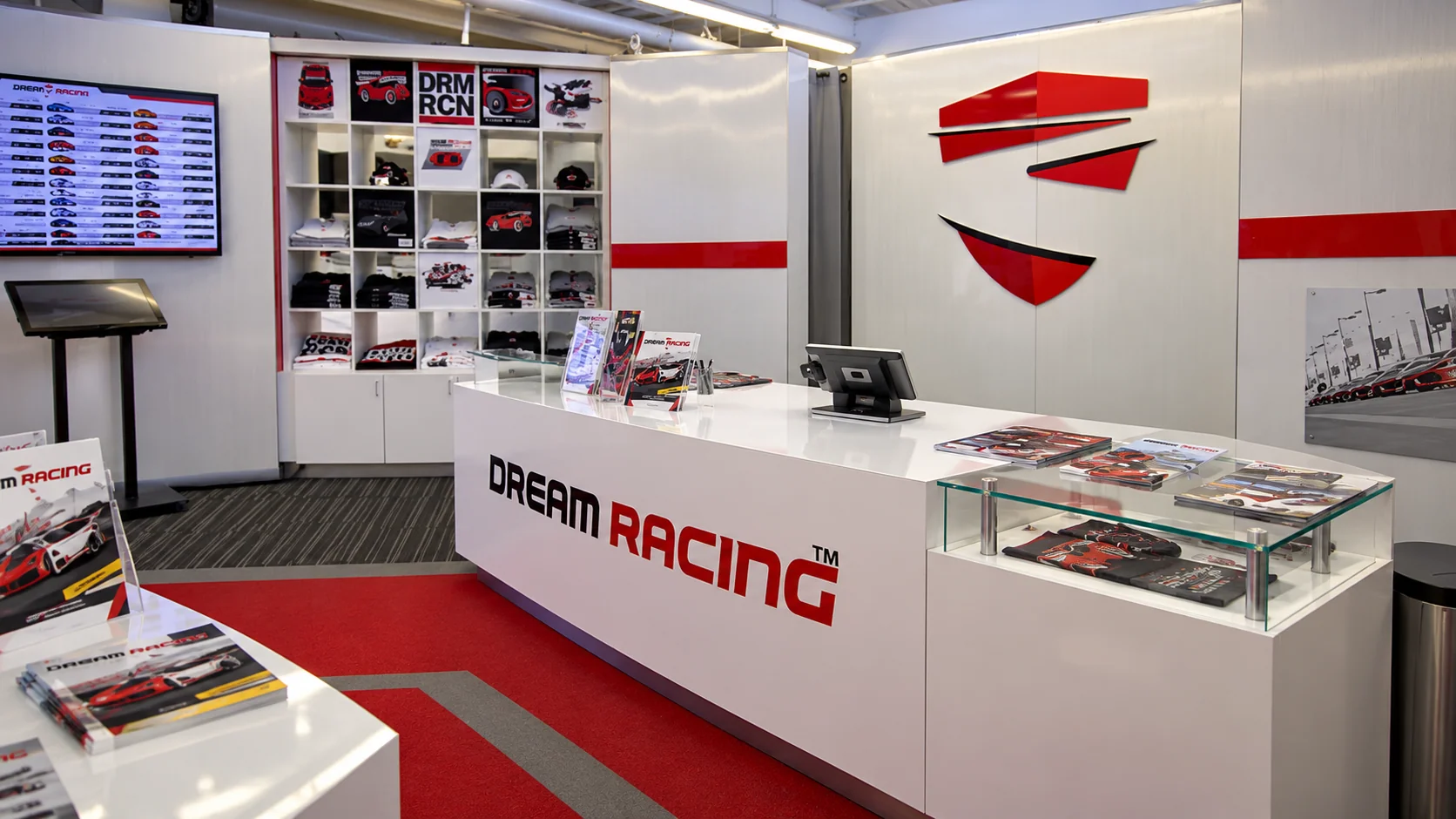 Dream Racing’s registration counter, merchandise shelves and red wall emblem
