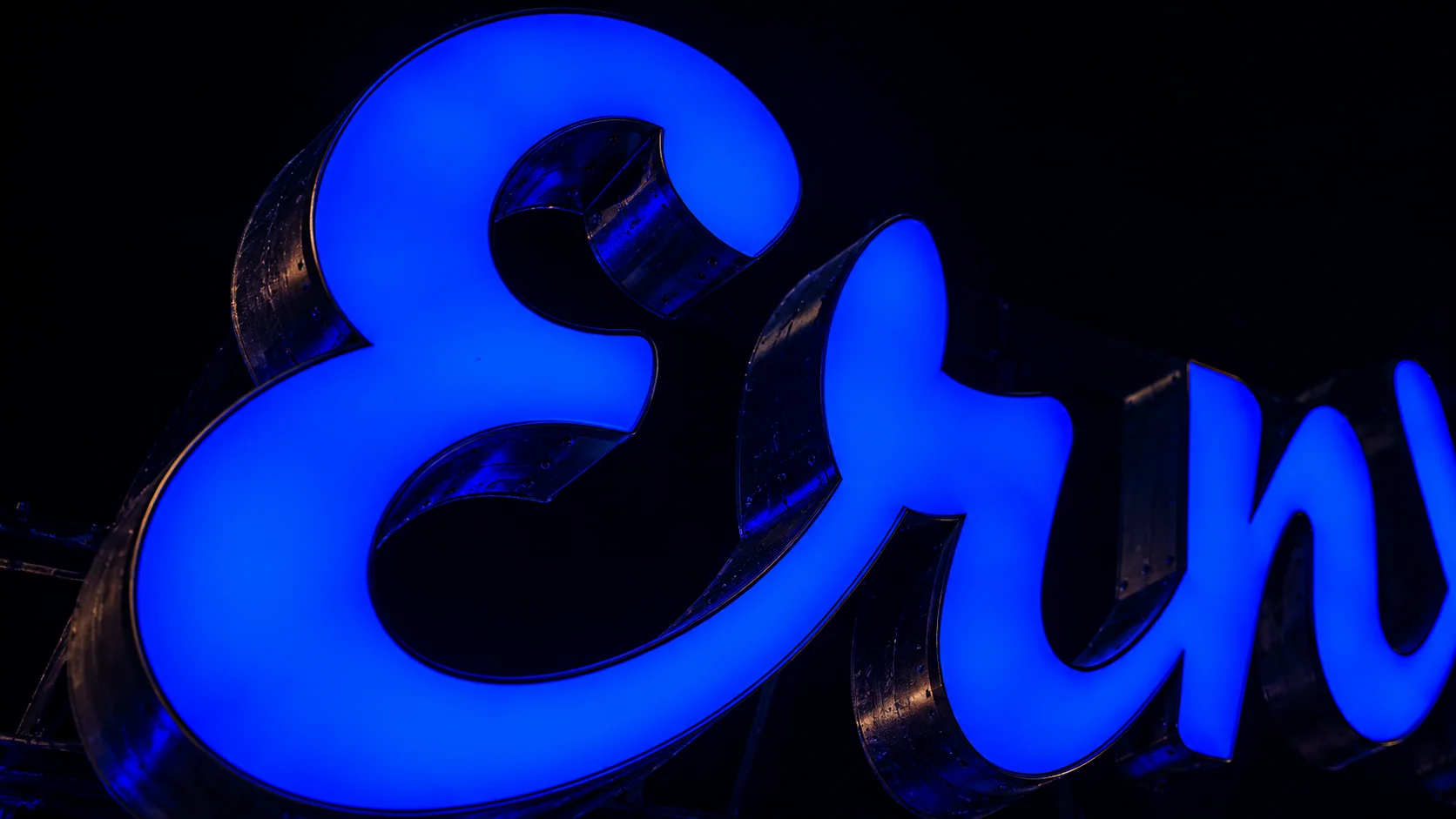 A blue-lit cursive sign fragment at the Neon Museum