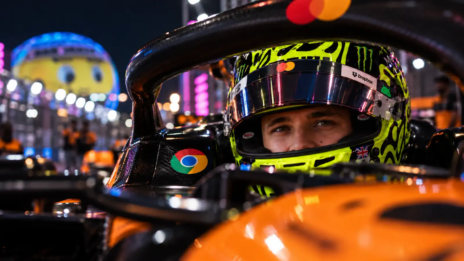 Lando Norris in his racing helmet under Las Vegas night lights.
