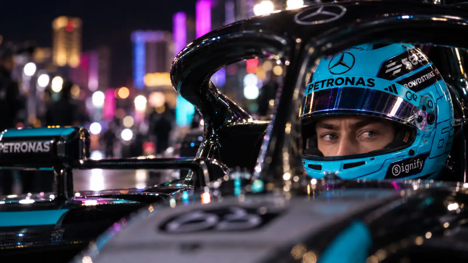 George Russell in his racing helmet under Las Vegas night lights.