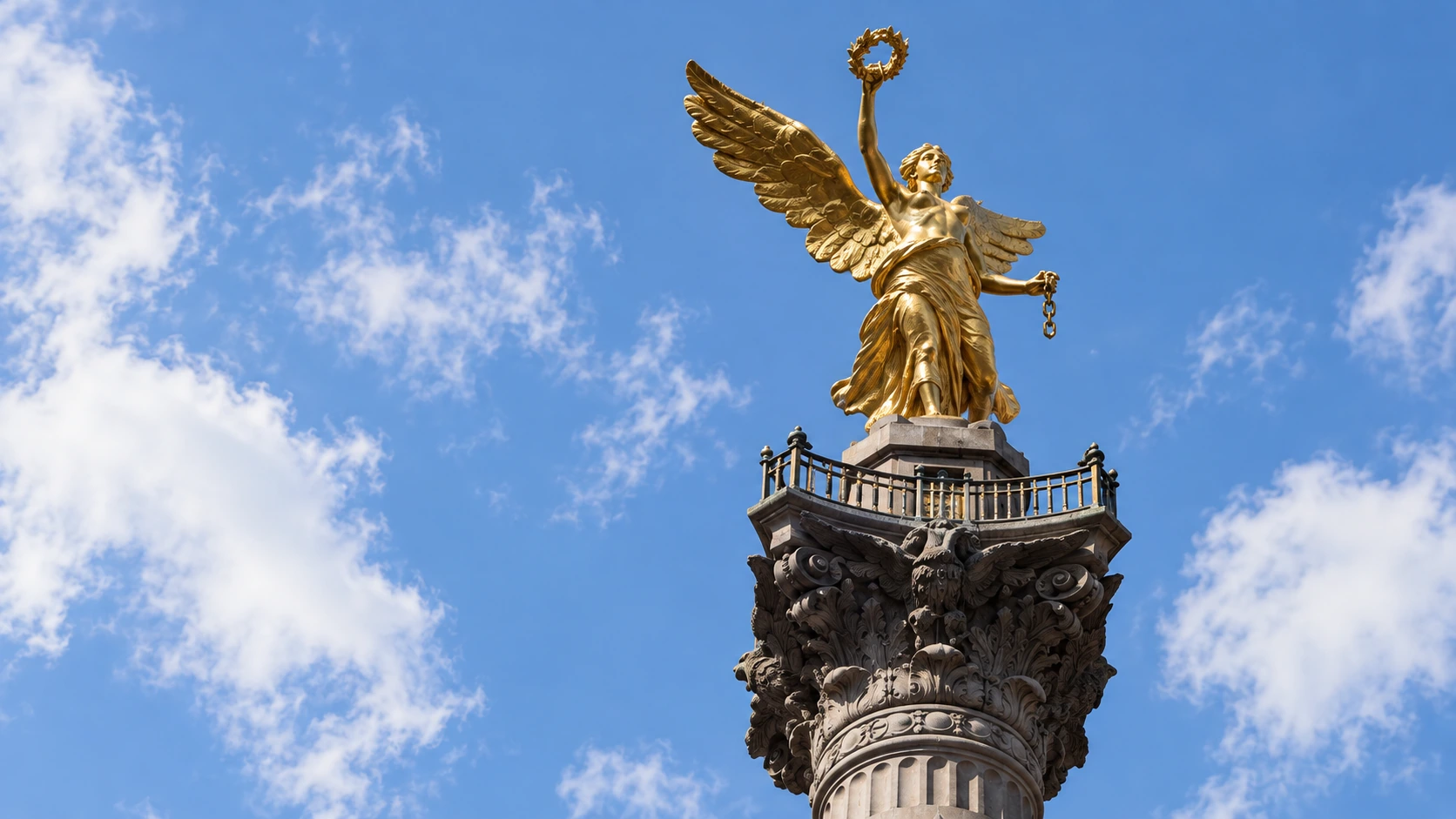 The gold winged Victory and ornate column capital at the Ángel