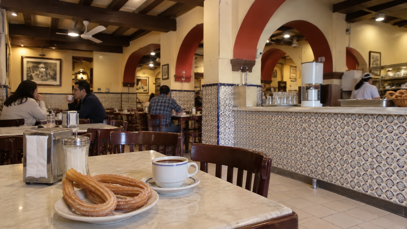 Patterned tilework, red arches and timber tables inside El Moro’s historic branch