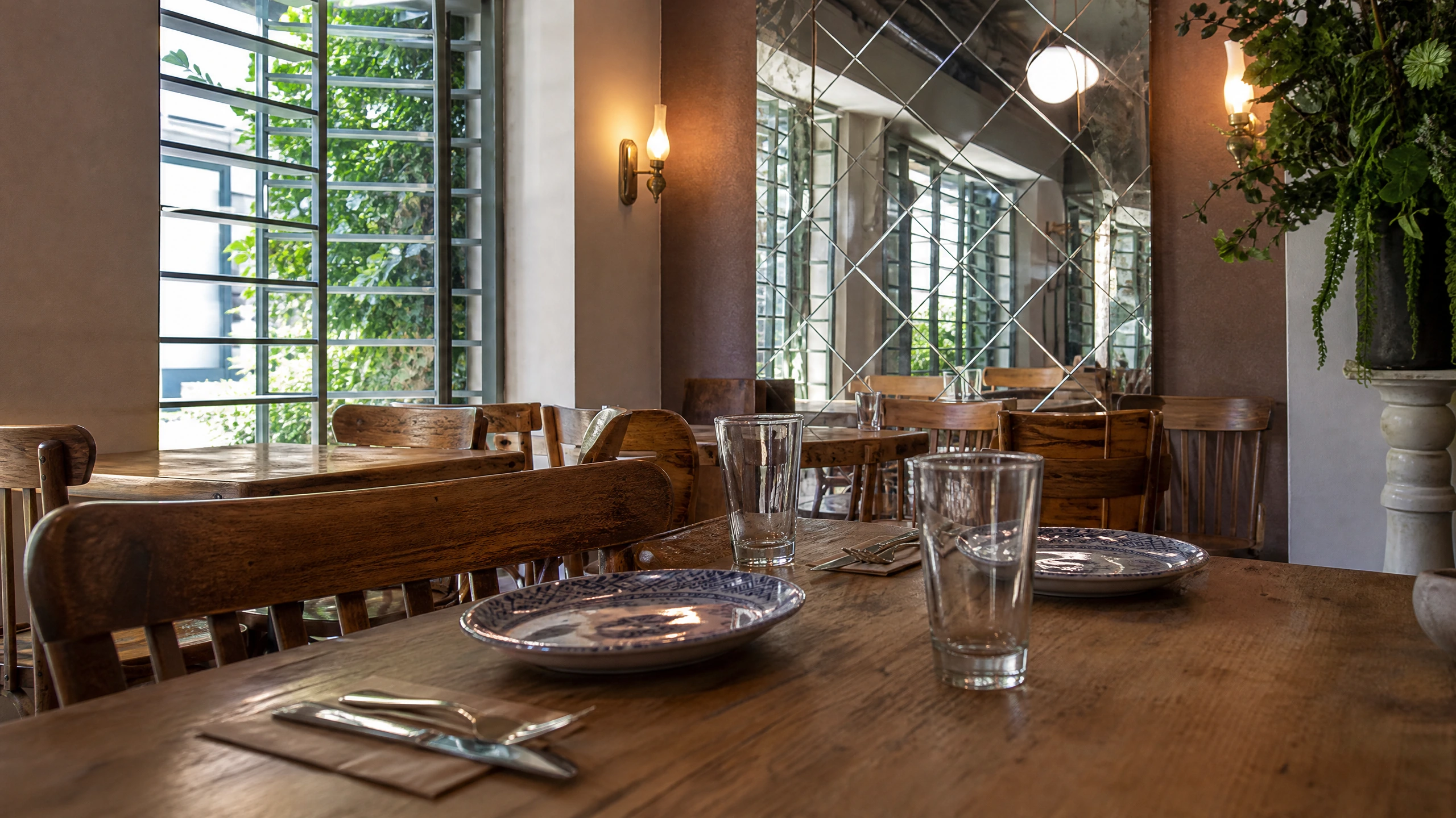 A set timber table beside Lardo’s window and diamond-patterned mirror