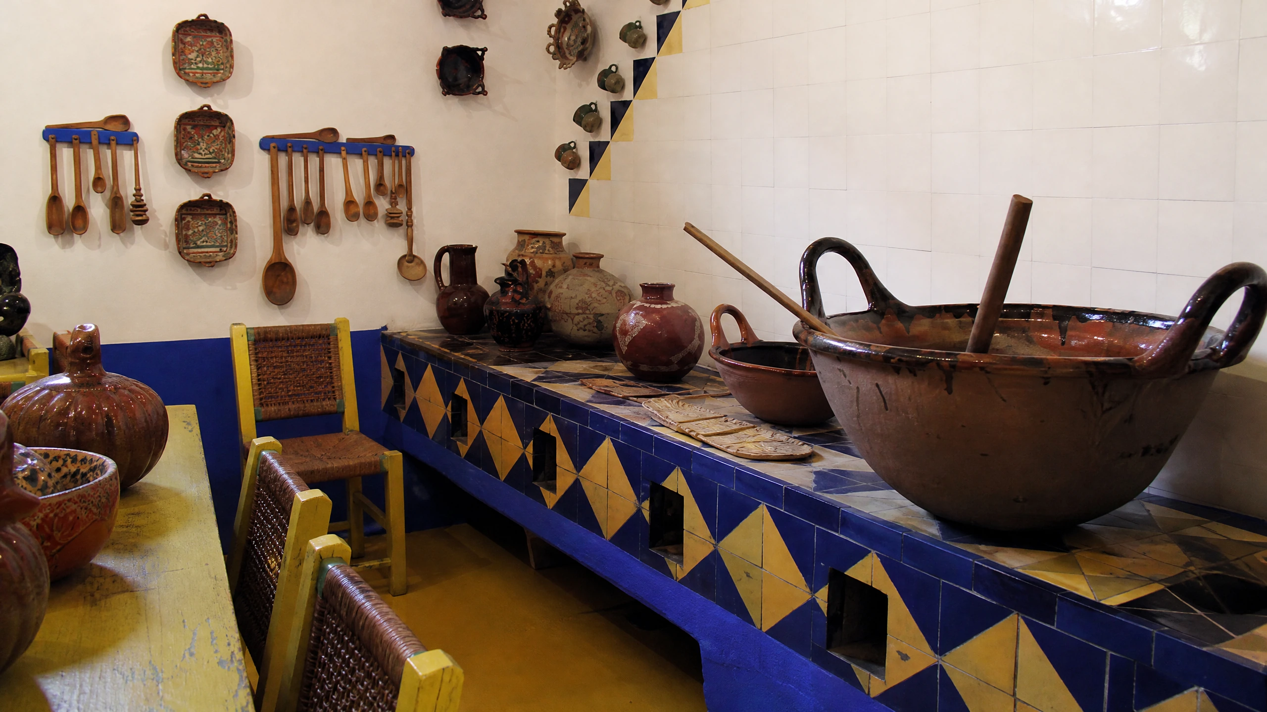 Blue and yellow tiled counters, pottery and furniture in Casa Azul’s kitchen