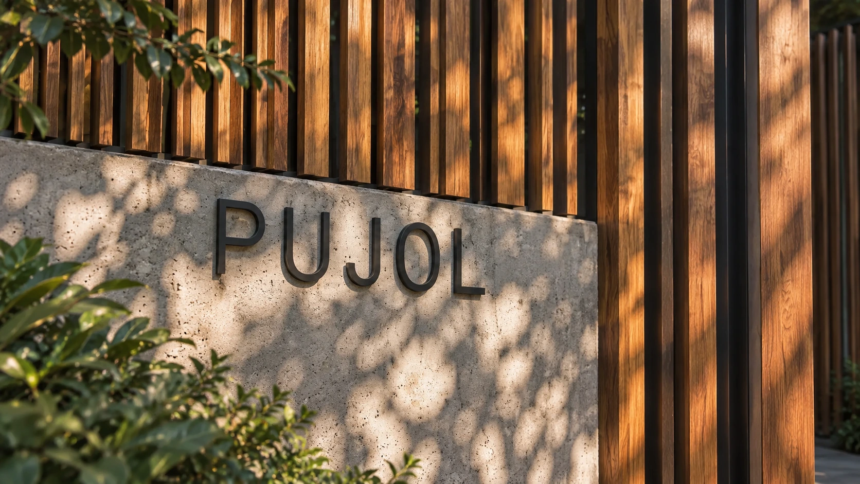 Pujol lettering on the concrete entrance wall beneath timber slats