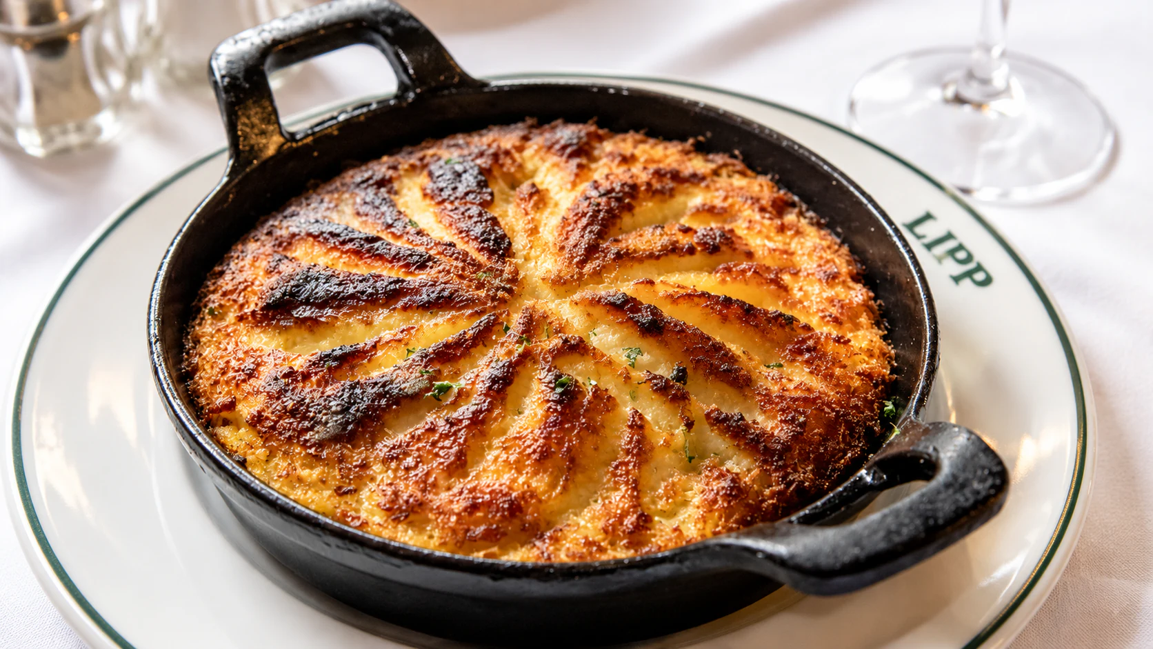 Brandade de morue, with a browned ridged surface, served in a black handled baking dish.