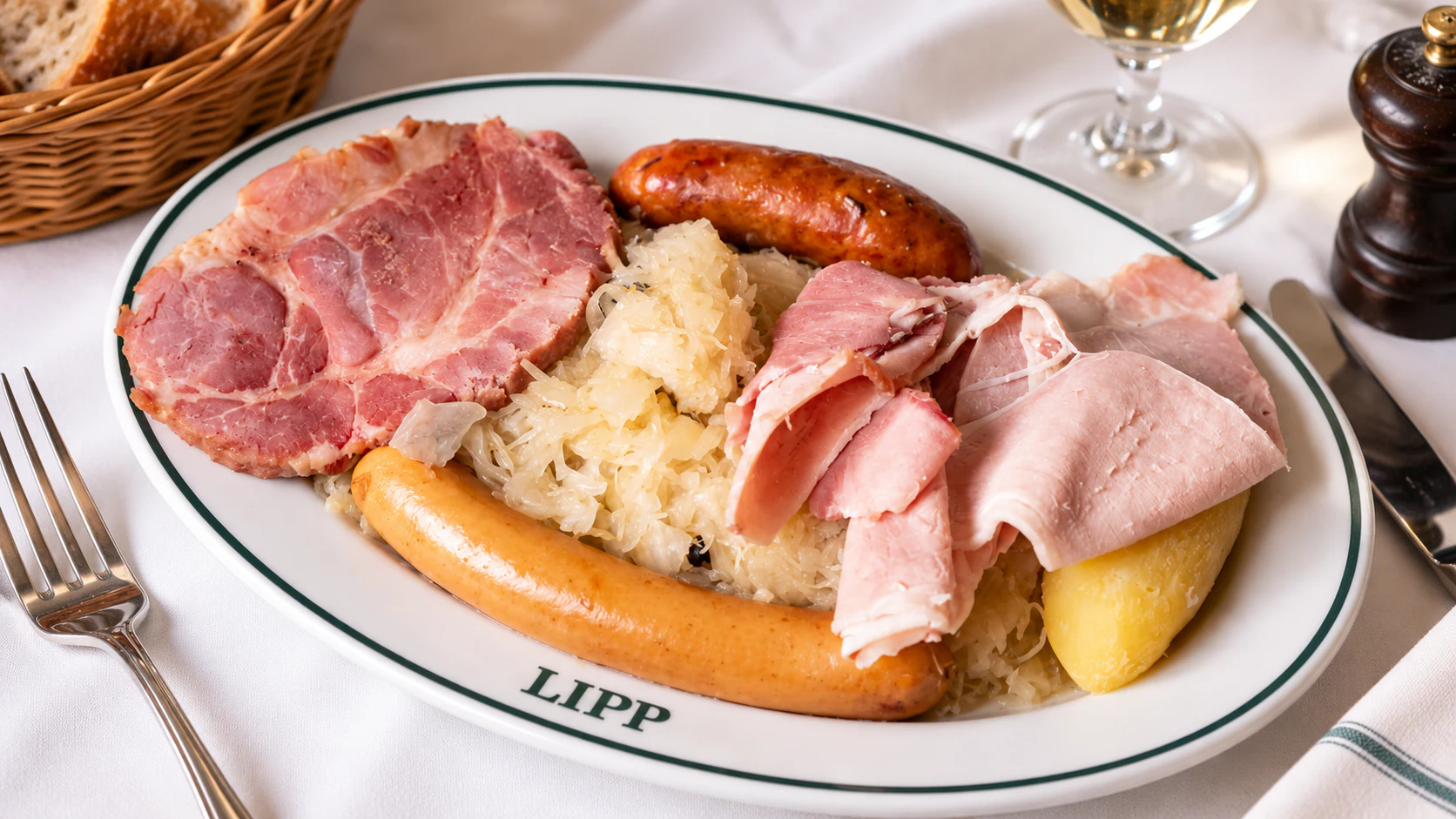 Choucroute at Brasserie Lipp: sauerkraut with sliced pork, sausage and potatoes on a green-rimmed platter.