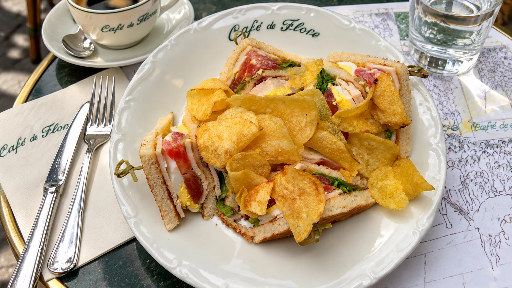 Chicken club sandwich with bacon, tomato, lettuce and egg, served with crisps at Café de Flore.