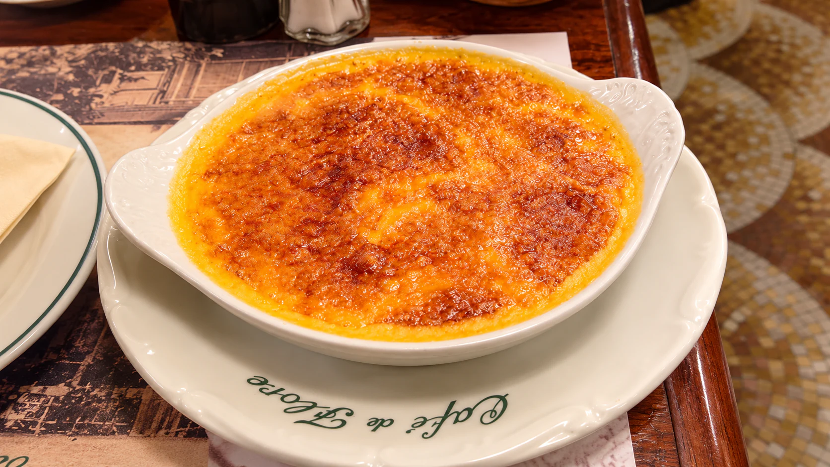 Welsh rarebit, a browned Cheddar-and-beer topping over toast in a white baking dish, at Café de Flore.