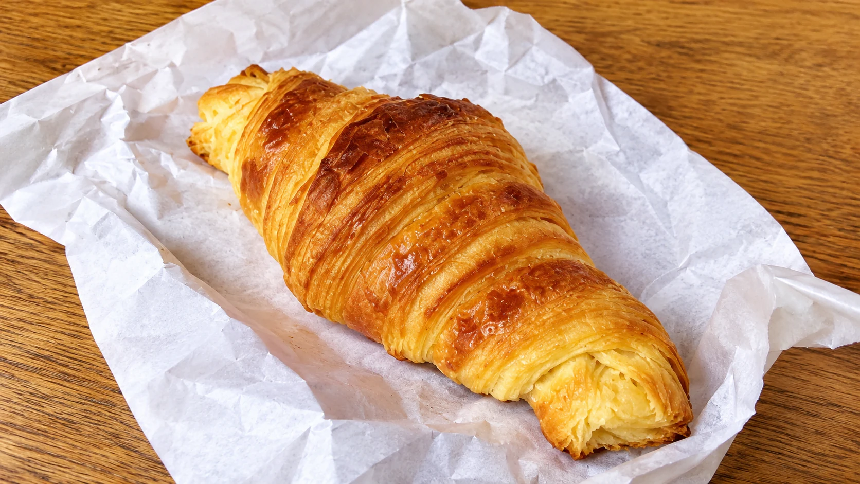 A butter croissant from Du Pain et des Idées, with a ridged golden crust and pointed ends.