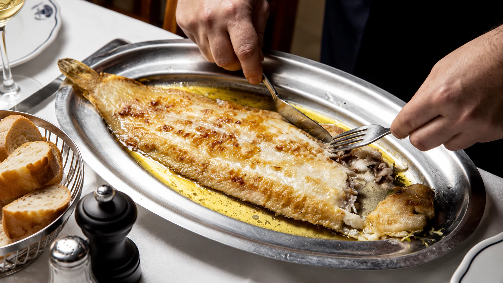 Sole meunière on an oval metal platter, ready for tableside filleting.