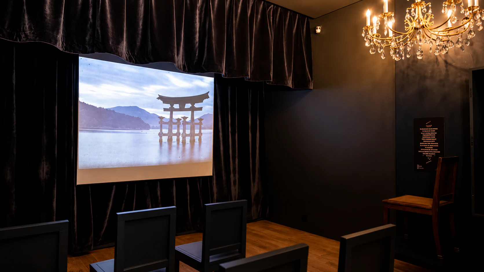 The projection cabinet, with a historical image on screen beneath a chandelier.