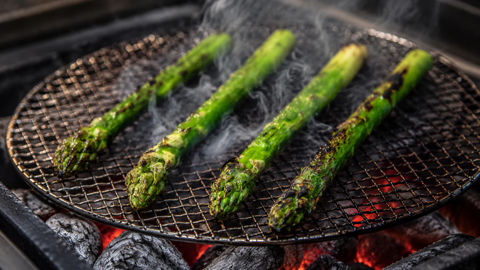 Green asparagus cooking over charcoal in the Astrance kitchen