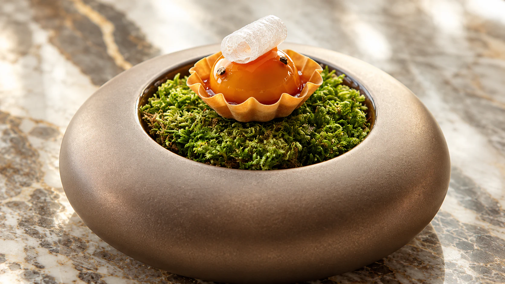 Glazed orange tartlet presented over moss at Le Jules Verne