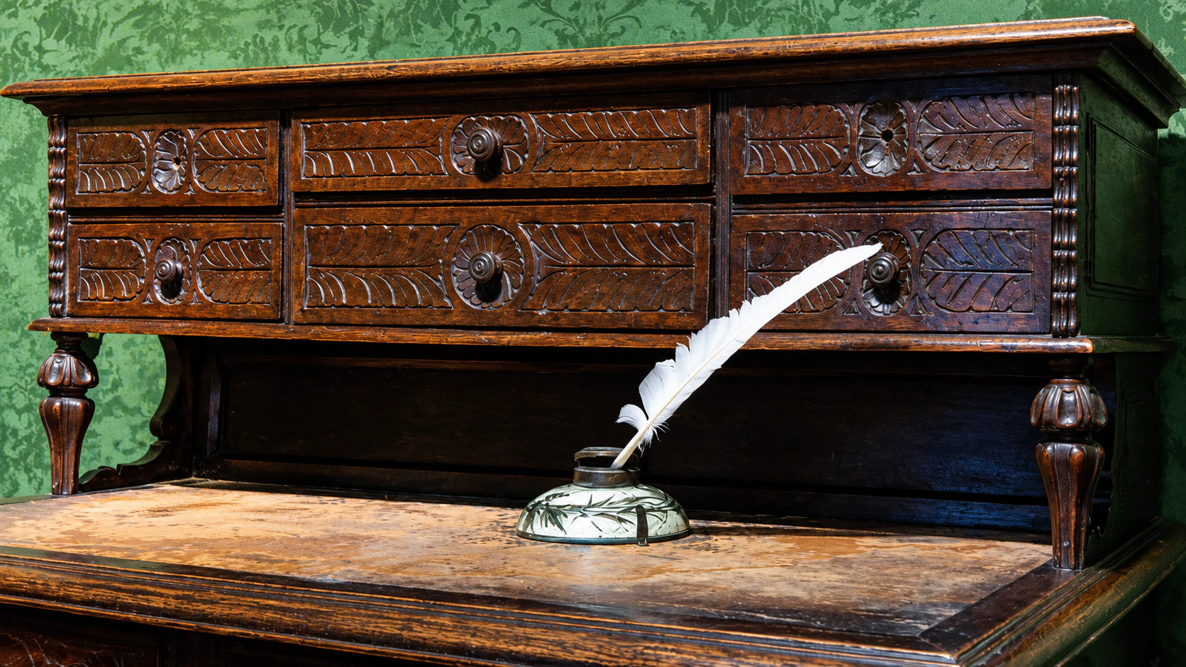 Carved writing desk, quill and glass inkwell at Maison de Victor Hugo