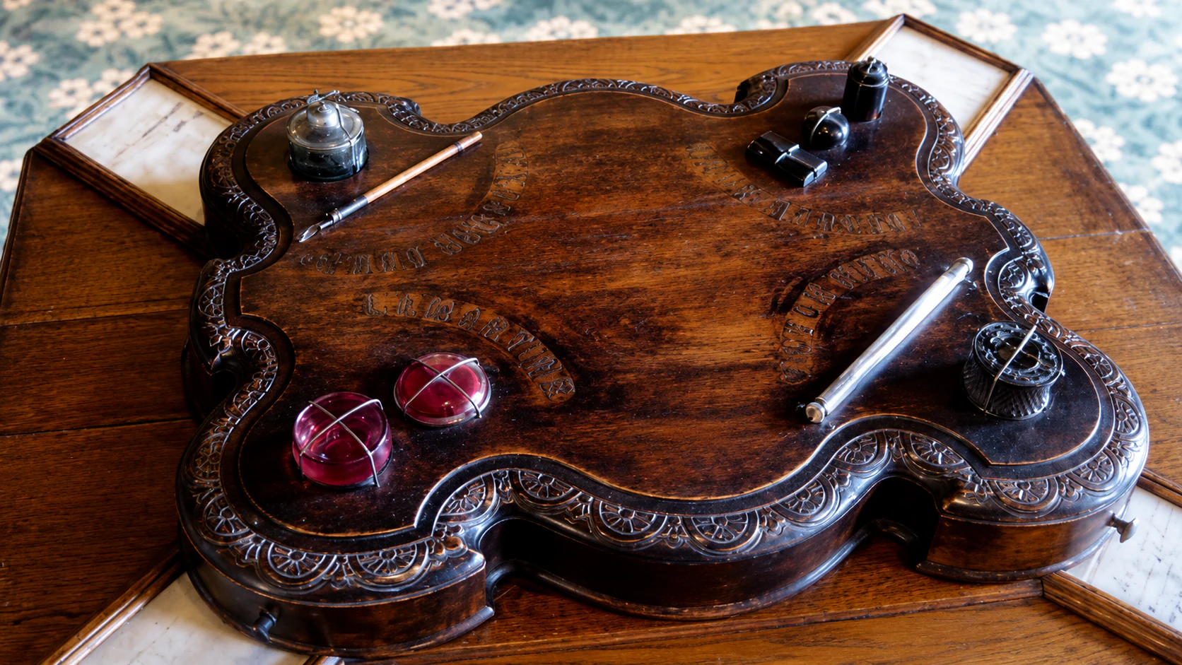 Carved writing surface and four inkwells at Maison de Victor Hugo